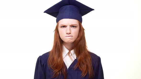 Nervous Ginger Caucasian Graduate Girl Standing on White Background in Blue Academical Dress with