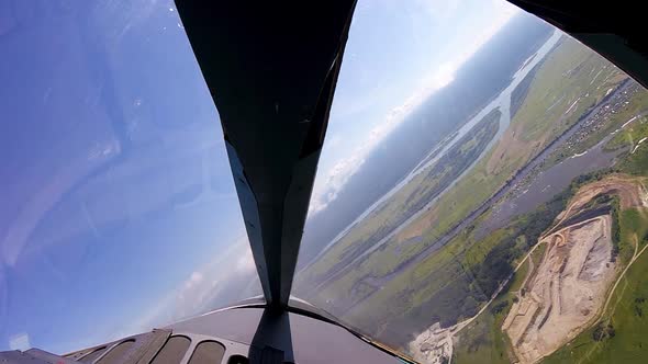 View Through Airplane Window Porthole with Cultivated Fields Near the Blue Sky