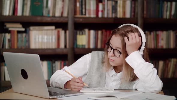 Focused Young Woman School Wear Headphones with Glasses Learn Watching Online Webinar Webcast Class