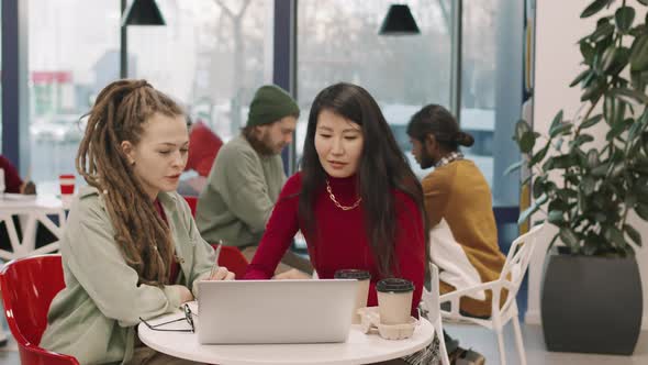 Female Colleagues Discussing Work in Cafeteria