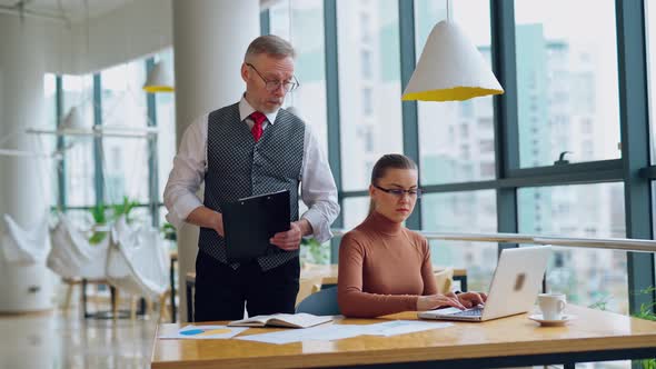 Mature man and a young woman in the office