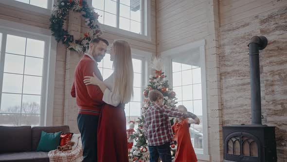 Parents Dancing Together and Kids in the Background Too in Christmas Atmosphere