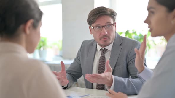 Angry Middle Aged Businessman Scolding Young Businesswoman