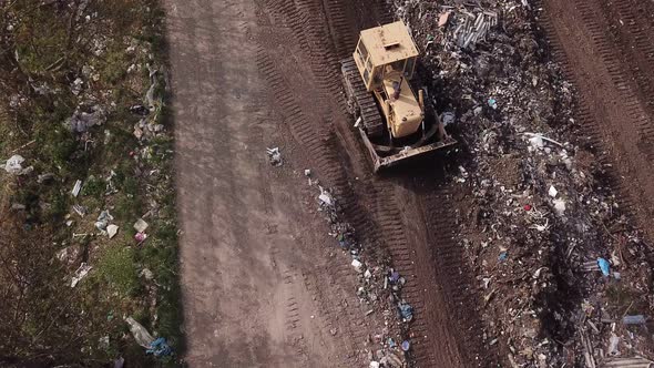 Bulldozer Collects Garbage in a Pile
