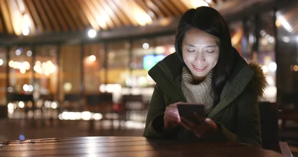 Woman using smart phone at night