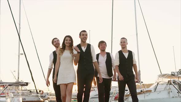 Group of People on the Harbor Background at Sunset