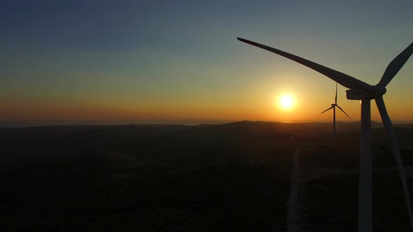 Close up aerial view of windmill blades at sunset alt