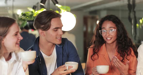 Close Up View of Millennial Joyful People Having Conversation While Holding Cups. Happy Friends