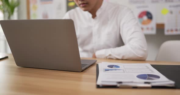 A man holding a coin and putting it on a document