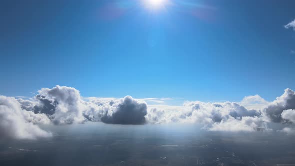 Aerial View From Airplane Window at High Altitude of Earth Covered with Puffy Cumulus Clouds Forming