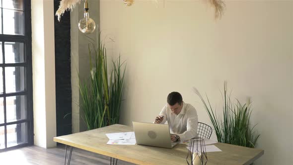 businessman working behind laptop in a stylish office