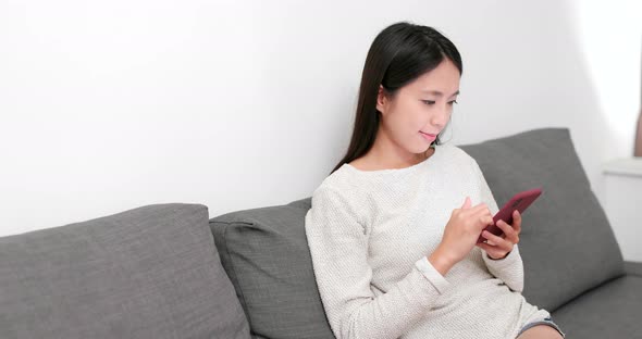 Woman working on cellphone at home