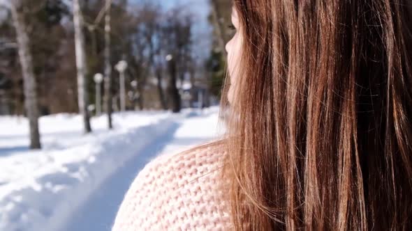 Beautiful Young Woman in Knitted Sweater in Winter Park