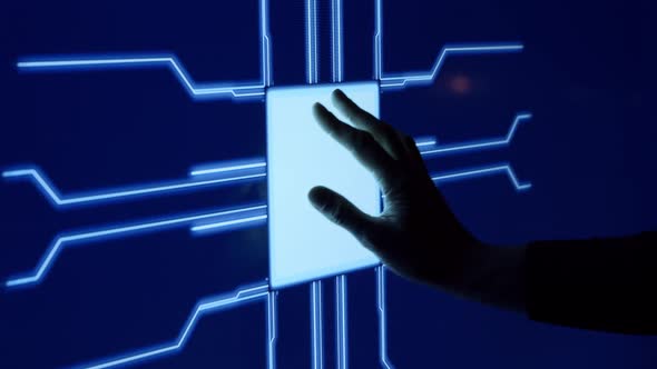 Human finger is pressing a digital button on a glowing touchscreen.