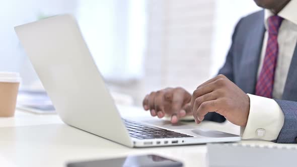 Close Up of Hands of African Businessman Working on Laptop in Office