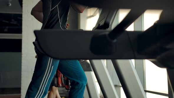 Slow Motion Footage of Athletes Running on Treadmills in a Gym