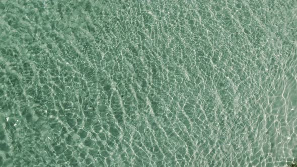 Fresh clean water of Mediterranean sea ripple against sunlight, aerial top down view