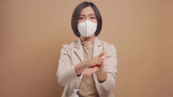 Asian business woman wearing hygiene mask used sanitizer gel for washing her hands isolated