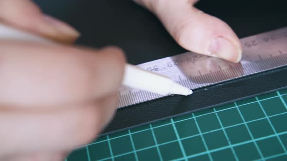 Skilled Tailor Draws Line on Leather Cloth with White Pen