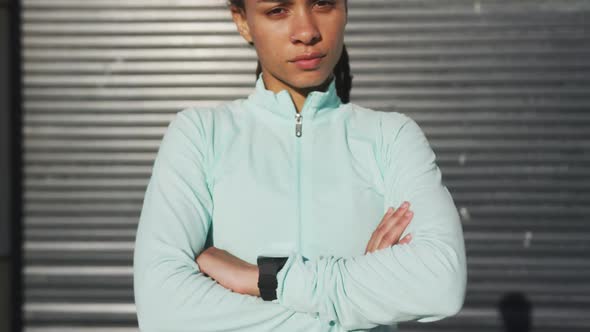 Portrait of african american woman in sportswear with arms crossed in street