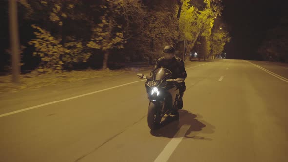 Male Biker Moving on His Modern Motorcycle at Evening City Street
