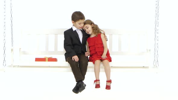 Little Boy Straightens His Hair To His Girlfriend and Embraces Her Trembling. White Background