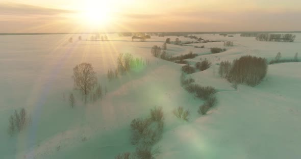 Aerial View of Cold Arctic Field Landscape Trees with Frost Snow Ice River and Sun Rays Over Horizon