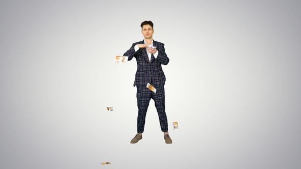 Young happy businessman dancing and throwing money on gradient