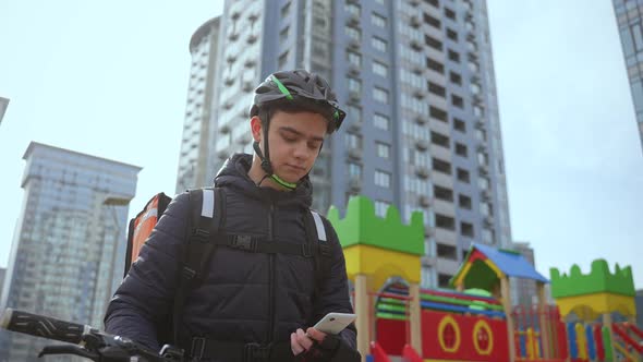 Deliveryman Taking Online Order on Phone Outdoors