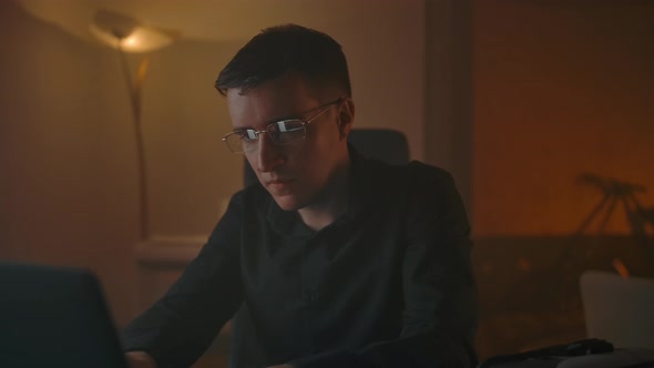 A Man Takes Off His Glasses While Working in Front of a Laptop and Does an Eye Massage