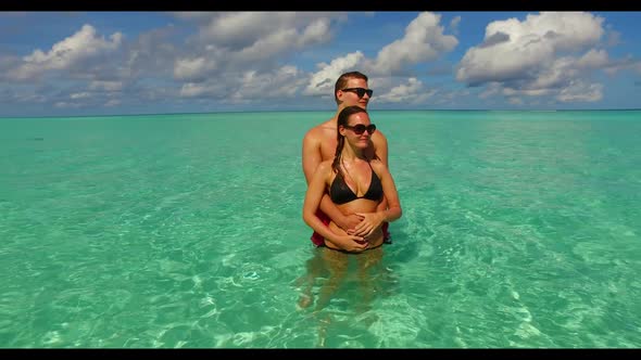 Guy and girl engaged on luxury resort beach trip by blue ocean and white sandy background of the Mal