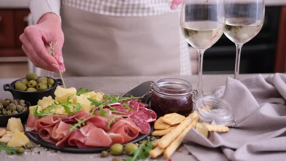 Meat and Cheese Plater at Domestic Kitchen  Woman Dips Cheese Into Sauce