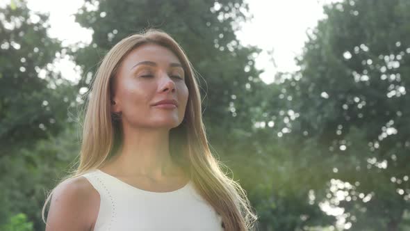 Sliding Cropped Shot of a Woman Sitting in Lotus Position on the Grass