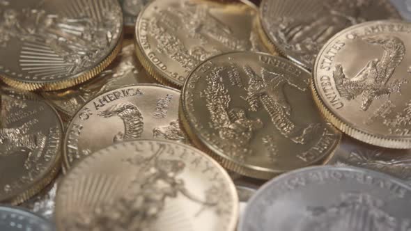 Gold American Eagles on a pile of Silver American Eagles spinning left