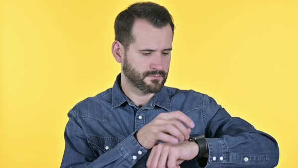 Professional Beard Young Man Using Smartwatch, Yellow Background