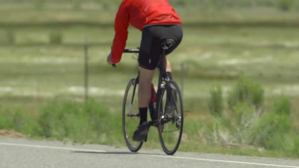 A man road biking on a scenic road.