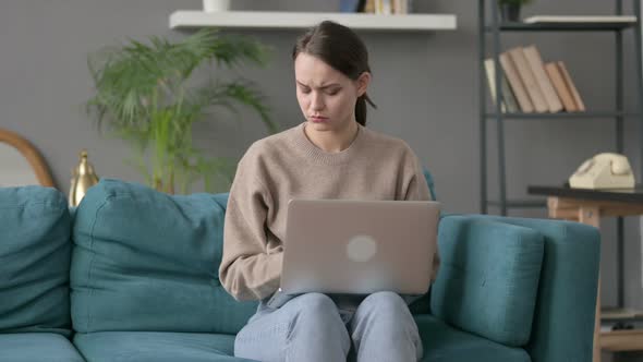 Woman with Laptop Having Wrist Pain on Sofa