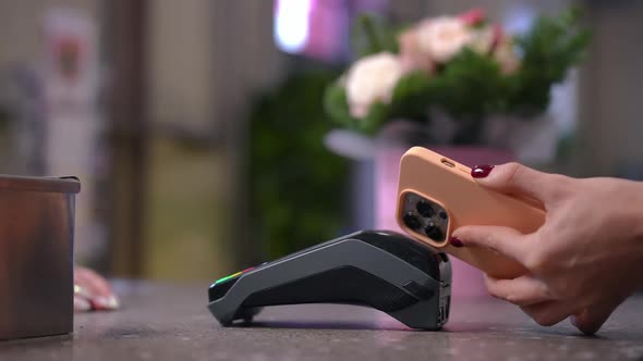 Side View Unrecognizable Woman Paying with Smartphone in Flower Shop Indoors