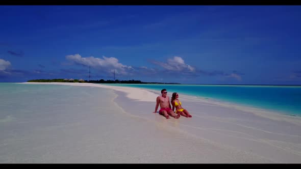 Man and lady sunbathing on perfect shore beach trip by shallow sea and bright sand background of the