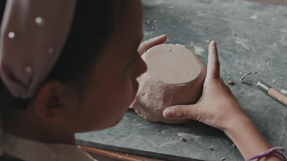 Girl Trimming Bowl of Clay