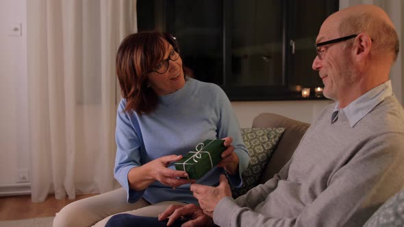 Happy Senior Couple with Gift Box at Home