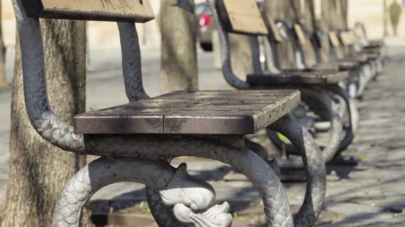 A Row of Empty Benches on a Street in an Urban Area - Focused Closeup