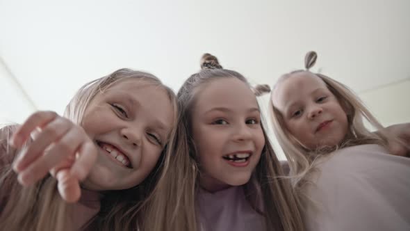 Three funny girls friends looking at camera