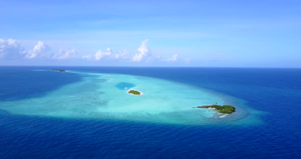 Luxury flying travel shot of a white sandy paradise beach and blue ocean background in colourful 4K