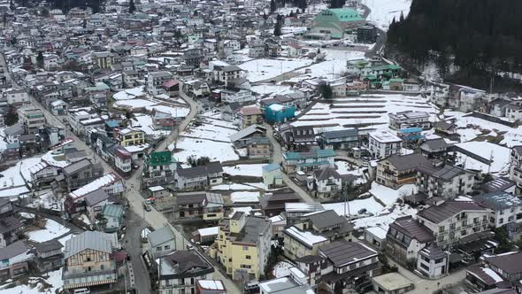 aerial of nozawa onsen village surrounded by mountains in nagano japan during winter