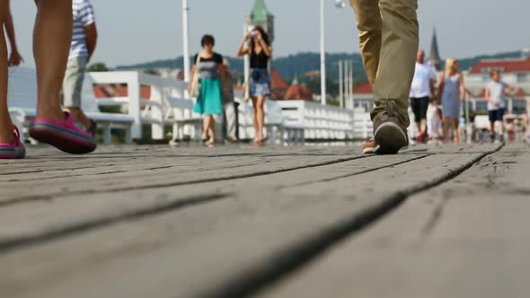 Footsteps of people strolling along old wooden pier, enjoying beauty of sea