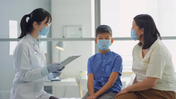 Asian Mother and Kid Visiting Doctor during Pandemic