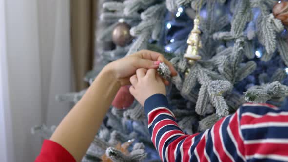 Little Boy Helping His Mom to Decorate Christmas Tree