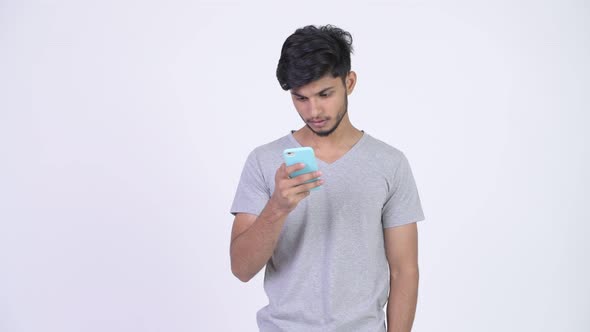 Young Stressed Bearded Indian Man Using Phone and Getting Bad News