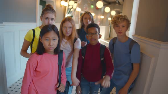 Group of Multiethnic Children Students Showing Thumbs Down Standing in School Corridor